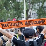 Migrants In, Murdoch Out”.